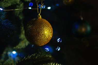 Yılbaşı ağacında altın top ve arka planda bokeh ışıkları. Noel