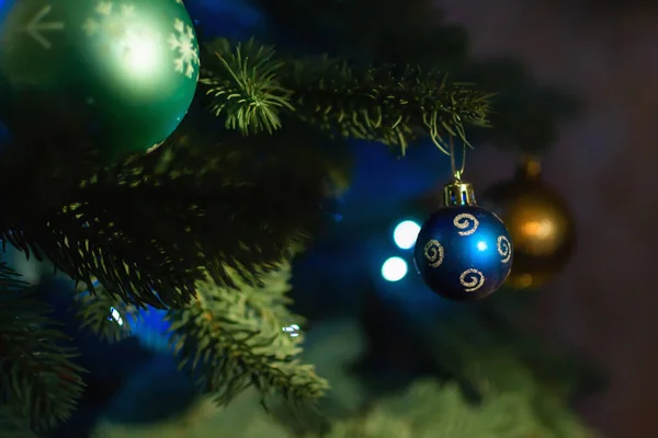Blue ball on Christmas tree with bokeh lights on background. Christmas decorations