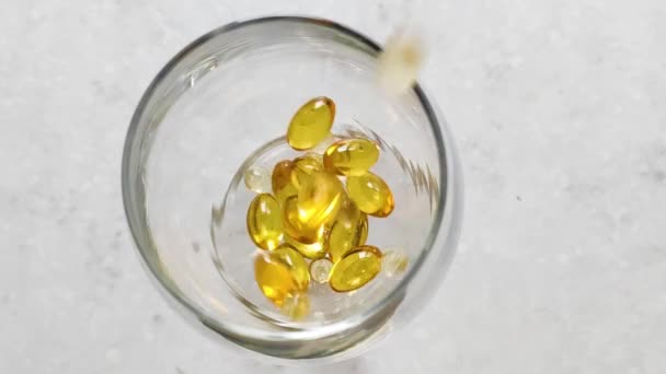 Golden Pills Omega Glass Medicine Healthcare Concept White Background Close — Stockvideo