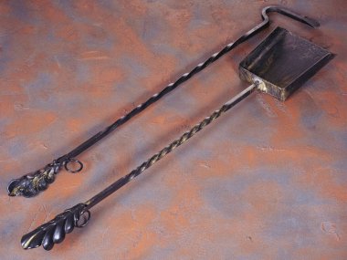 Kömür için metal kepçesi ve poker, paslı arka planda şömine aksesuarı olarak kullanılıyor.