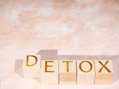 Açık turuncu arkaplanda tahta bloklar üzerine detoks metni