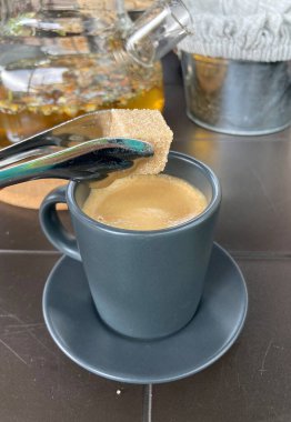 Bir fincan espresso 'ya şeker ekleniyor. 