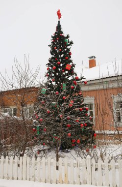 Şehir meydanında parlak süslemeleri olan kocaman bir Noel ağacı.
