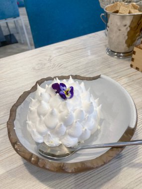 Restoranda yenilebilir çiçekli güzel bir pavlova pastası.