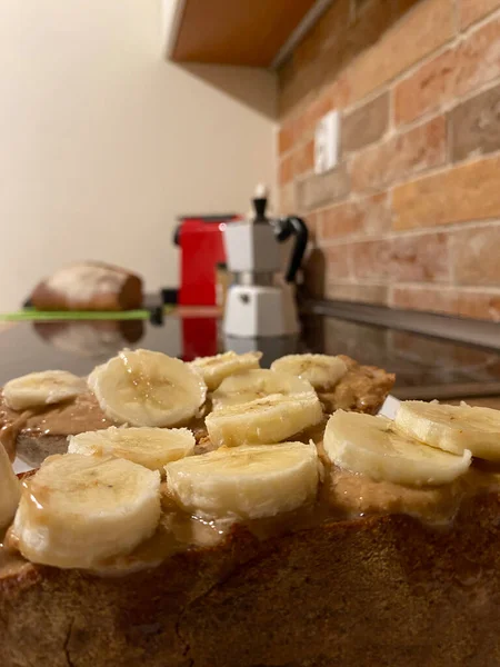 Healthy breakfast ready to eat with fitness bread, peanut butter, nuts and bananas homemade in the kitchen.