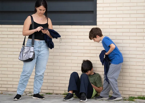 家族は通りに滞在し 中毒性があり 現代的なガジェットに取りつかれています ストック映像だ 母親がスマートフォンを使い過ぎている間に携帯電話を使う子供たちは お互いを無視しないように — ストック写真