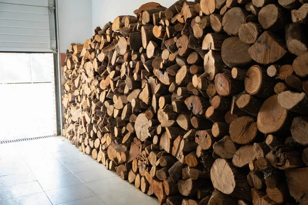 Kışın ısınmak için yakacak odunları olan deponun içinden bir görüntü. Yakacak odun yığını. Ağaç kütükleri yığını.
