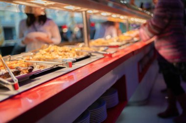 Öğle yemeğinde yemek bekleyen ve yemek seçen insanların soyut bulanık görüntüsü. - Ev yemekleri konsepti..