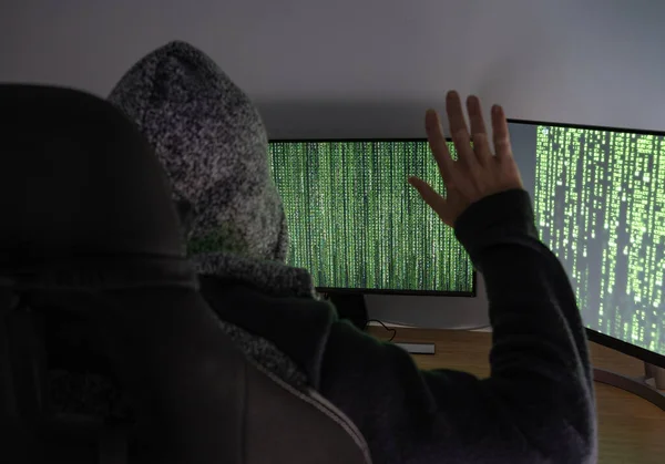 internet Hacker criminal trapped in front of computer with hands up
