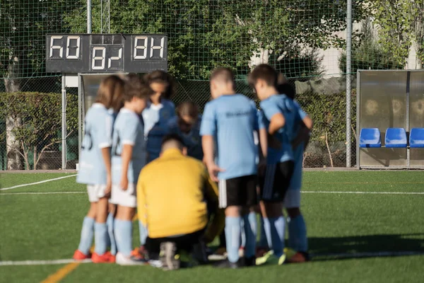 Blurred Soccer football background. Coach giving young soccer team instructions. Youth soccer team together before final game. Football match for children. Boys group shout team. Coach briefing.