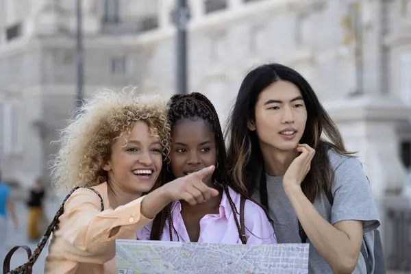 Група Молодих Багатоетнічних Усміхнених Туристів Які Відвідують Мадрид Вказують Пальцем Стокове Зображення