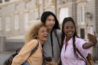 Madrid 'de üç etnik çeşitlilikte heyecanlı genç turist selfie çekiyor..