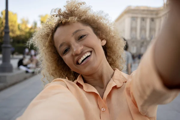 Brazilian ethnicity taking a selfie in Madrid city.