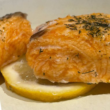 Limonlu fırında somon ve beyaz tabak arka planında şifalı otlar..