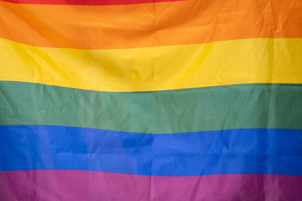 Гордость-гей радужный флаг, размахивающий чистым голубым небом.