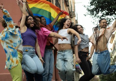 Madrid 'in chueca caddesindeki gökkuşağı bayrağından heyecanlanan geniş bir grup gay' in düşük açılı görüntüsü.
