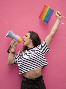 Megafonla bağıran ve LGBTQ toplumunu destekleyen bir gökkuşağı bayrağı tutan transseksüel kadının portresi.