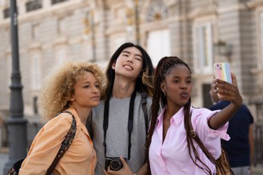 Madrid 'i ziyaret ederken selfie çeken çok ırklı genç turistler grubu.