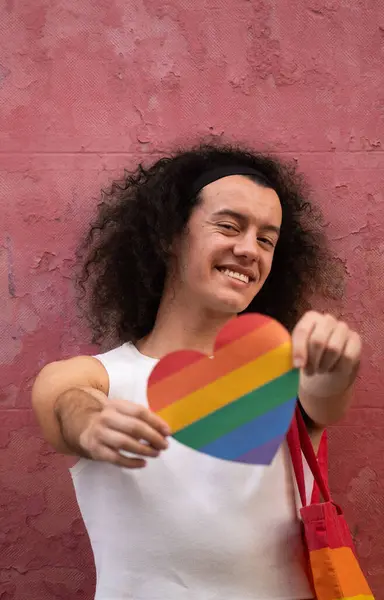 Gülümseyen homoseksüel bir adamın gökkuşağı kalbini göstermesi, Igbt topluluğuna ait olmaktan gurur duyuyor.. 