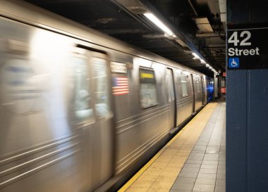 Hızlı hareket eden metro treni New York 'taki 42. Cadde istasyonuna varıyor.