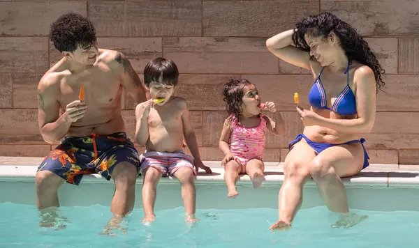 Aile yazın tadını çıkarıyor, havuz kenarında buzlu şeker yiyor.