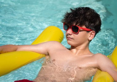 Havuzda gün ışığının tadını çıkaran genç bir adam