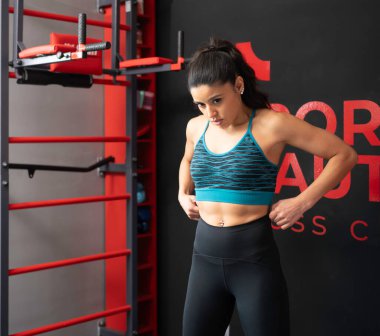 Sporcu kadın spor salonunda eğitime hazırlanıyor..