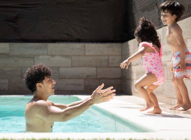 Latin babası, kızının güneşli bir yaz gününde havuza atladığını görmek için bekliyor.