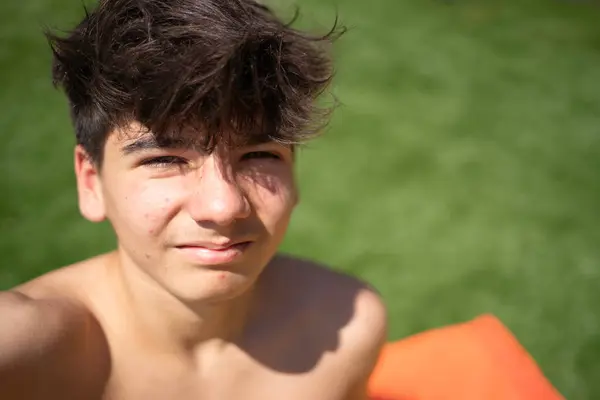 Yaz günü dışarıda dinlenen bir gencin selfie 'si: fotokopi çekilen güneş ışığının tadını çıkaran mutlu ergen çocuğun portresi