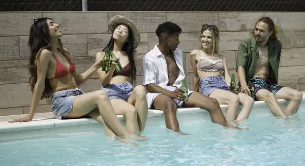 Bir grup genç, havuz partisinde yaz tatilinin tadını çıkarıyorlar.