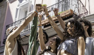 Çeşitli genç aktivist grupları gökkuşağı bileziği takıyor ve yumruklarını birlikte kaldırarak lgbtq hakları için bir gösteri yapıyor, tombul, Madrid, İspanya 'daki birlik ve gururu simgeliyor.