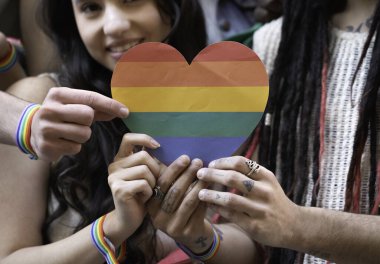 Eşcinsel gururu geçit töreninde ellerinde gökkuşağı kalbi olan bir grup insana yakın durun.