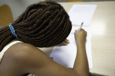 Sınav ya da sınavı bir sınıf ortamında tamamlayan siyah öğrenci kız.