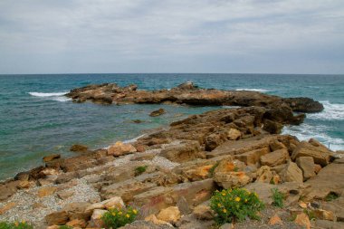 İspanya 'nın Valensiya bölgesinde deniz kenarında taşlı kayalar.