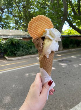 Elinde dondurma külahı tutan bir kadın.