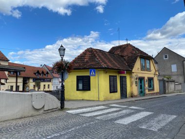 Geleneksel kırmızı kiremitli, kendine özgü sarı kır evi olan büyüleyici Avrupa sokak köşesi. 