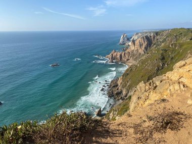 Çarpıcı uçurumları ve turkuaz suları olan muhteşem Portekiz Atlantik kıyıları. Zümrüt okyanustan taşlı deniz yığınları çıkar. Engebeli kıyı manzarası.