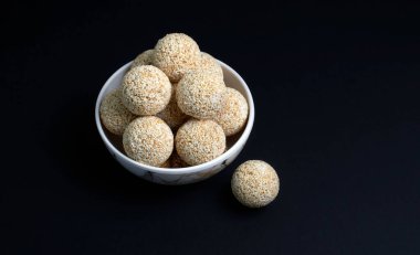 Makar Sankranti festivali, istiflenmiş ya da istiflenmiş Hint susamlı tatlı Rajgira laddu Amaranth tohumundan siyah arka planda yapılmış.