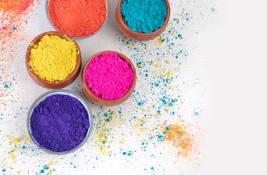 top view of colorful traditional holi powder in bowls isolated on white background.Space for text . happy holi.Concept Indian color festival called Holi
