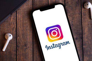 Instagram logo mobil uygulaması ekrandaki akıllı telefon iPhone 'unda defter, uçak modülü kulaklıkları ile yakın plan. Instagram akıllı telefonlar için fotoğraf paylaşım uygulamasıdır. Batum, Gürcistan - 5 Ekim 2022
