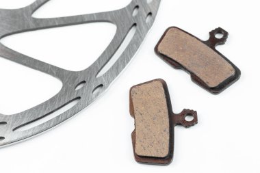 Beyaz arkaplanda fren balataları olan dağ bisikleti disk fren pervanesi