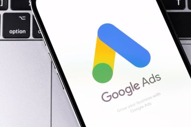 Google 'ın akıllı telefon iPhone ekranında logo mobil uygulaması, dizüstü bilgisayar kapatması. Reklamlar, temelde Google 'dan gelen bir arama reklamları servisidir. Batum, Gürcistan - 2 Mart 2023