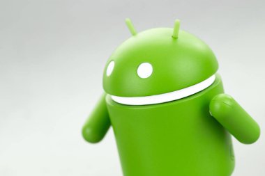 Google Android figürü gri arka planda yürüyor. Google Android akıllı telefonlar, tablet bilgisayarlar, e-kitaplar ve diğer cihazlar için bir işletim sistemidir. Batum, Gürcistan - 19 Mart 2023
