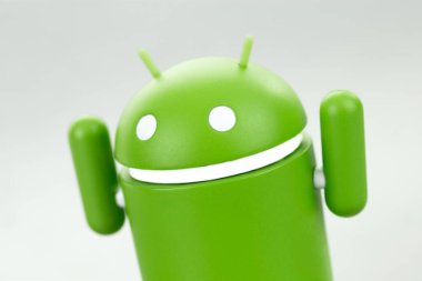 Elleri gri arkaplanda olan Google Android figürü. Google Android akıllı telefonlar, tablet bilgisayarlar, e-kitaplar ve diğer cihazlar için bir işletim sistemidir. Batum, Gürcistan - 19 Mart 2023