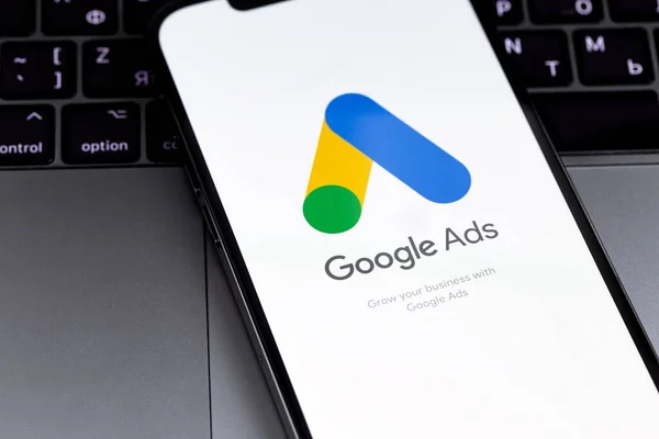 Google Ads logo mobil uygulaması MacBook 'la birlikte akıllı telefon iPhone ekranında. Reklamlar, temelde Google 'dan gelen bir arama reklamları servisidir. Batum, Gürcistan - 2 Mart 2023