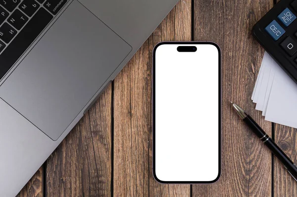 木製の背景に空白の透明画面とMacbookのクローズアップとモックアップスマートフォンのIphone Pro Max Appleは多国籍テクノロジー企業です ジョージア州バトゥミ 2022年3月6日 — ストック写真