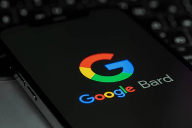 Google Bard (AI ChatBot) bir ekran akıllı telefon iPhone üzerinde bir klavye üzerinde logo. Ozan, Google tarafından geliştirilen konuşma amaçlı yapay zeka sohbet robotudur. Batum, Gürcistan - 26 Nisan 2023