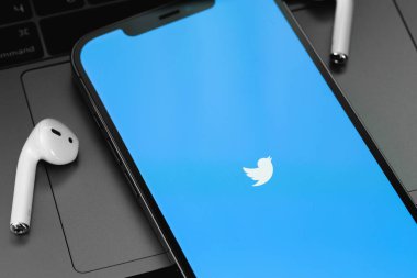 Mobil Twitter uygulaması ekranda AirPods kulaklıklı akıllı telefon iPhone 'unda. Twitter, mikroblog ve ağ iletişimi için bir sosyal medya hizmetidir. Batum, Gürcistan - 24 Nisan 2023