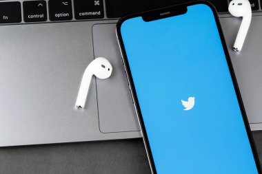 Mobil twitter uygulaması ekranda AirPods kulaklıklı akıllı telefon iPhone 'unda. Twitter, mikroblog ve ağ iletişimi için bir sosyal medya hizmetidir. Batum, Gürcistan - 24 Nisan 2023