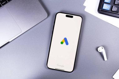 Google 'ın logo mobil uygulaması bir ekrandaki akıllı telefon iPhone' unda, iş yerinde. Reklamlar, temelde Google 'dan gelen bir arama reklamları servisidir. Batum, Gürcistan - 6 Kasım 2023